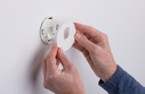 Hände montieren weiße Kunststoff-Wandhalterung mit ovalem Ausschnitt an glatter Wand für LED-Beleuchtung