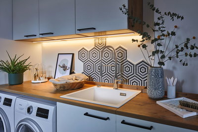 Moderne Küche mit weißem Spülbecken, Holzarbeitsplatte und hexagonalem Mosaikfliesenrückwand mit LED-Beleuchtung