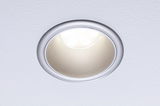 Round recessed LED light with silver aluminum frame installed in ceiling for modern lighting solutions