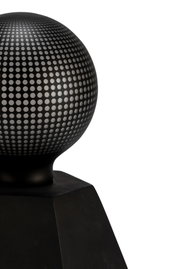 Sphère métallique noire à motif perforé sur base carrée, objet décoratif moderne