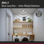 Abia 2 Deckenleuchte in Weiß mit Sensorfunktion in modernem Waschraum mit Wäsche und Körben