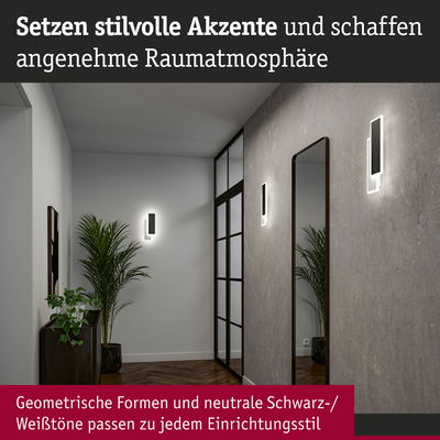 Moderne schwarze LED-Wandleuchten mit geometrischem Design an grauer Wand im Flur mit Spiegel und Pflanzen