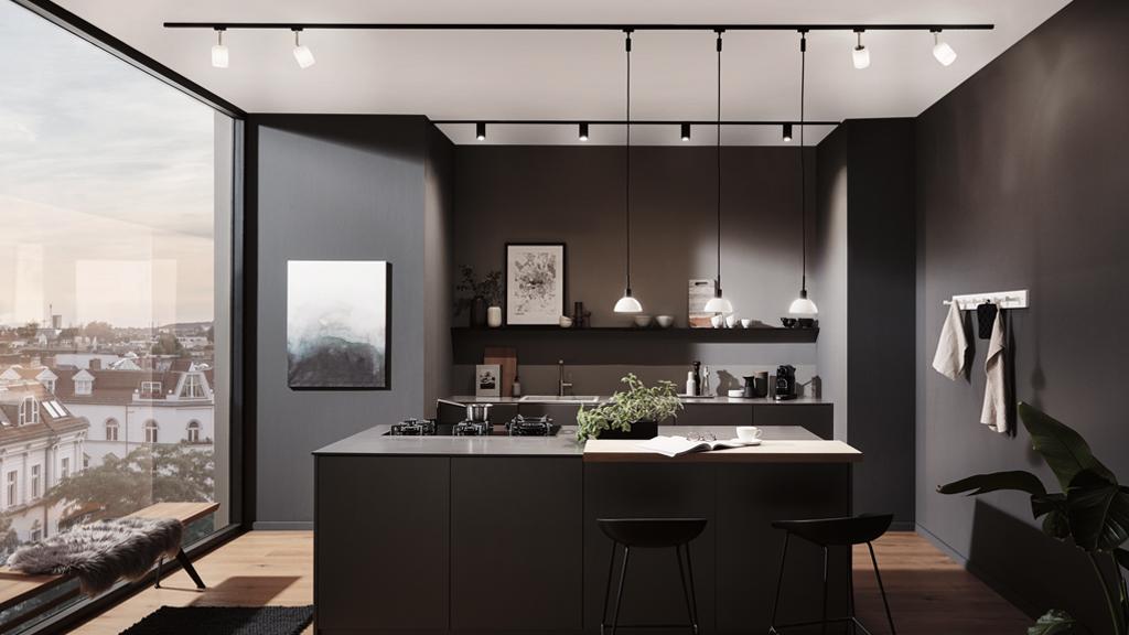 Cuisine moderne avec îlot noir, plan de travail en bois et éclairage LED sur rail minimaliste.