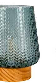 Blue-green glass lampshade with herringbone pattern on light wooden base for home lighting