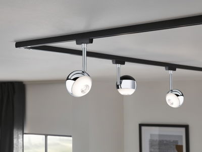 Modern ceiling spotlights with three round chrome lamps on black track for living room lighting