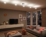 Moderne woonkamer met grijze bank, houten tafel en witte LED-kabelverlichting aan het plafond