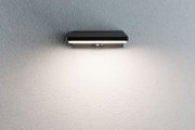 Black metal LED wall light with motion sensor on textured grey wall for outdoor lighting