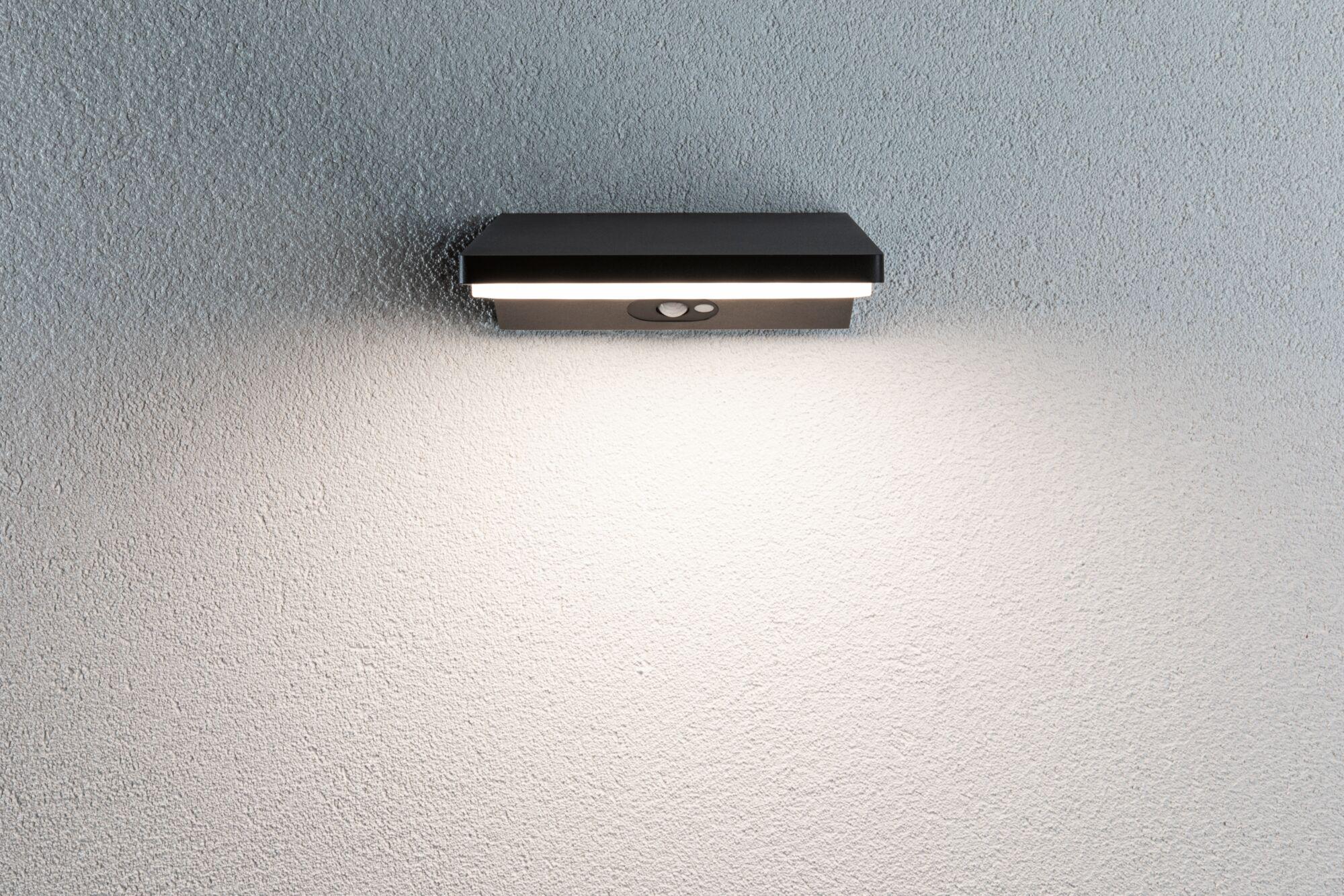 Black metal LED wall light with motion sensor on textured grey wall for outdoor lighting