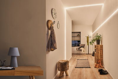 Moderner Flur mit MaxLED Flow LED-Lichtleiste in warmweiß, Holzfußboden und minimalistischer Einrichtung