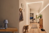 Couloir moderne avec bande LED MaxLED Flow blanc chaud, sol en bois et décoration minimaliste