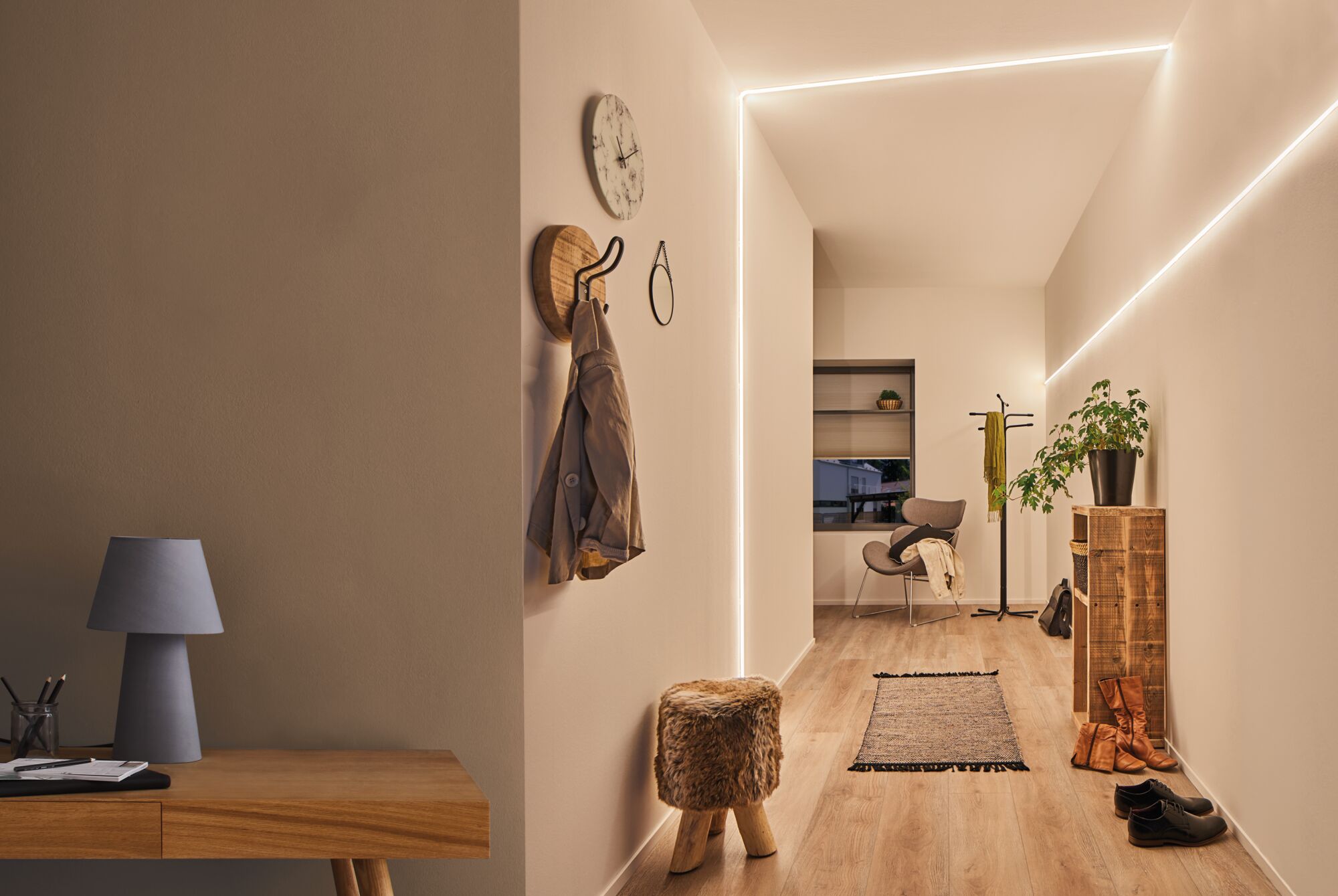 Couloir moderne avec bande LED MaxLED Flow blanc chaud, sol en bois et décoration minimaliste