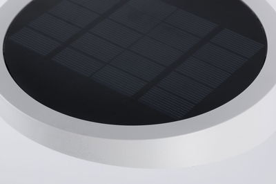 Round solar panel with black surface and white frame for energy-saving lighting