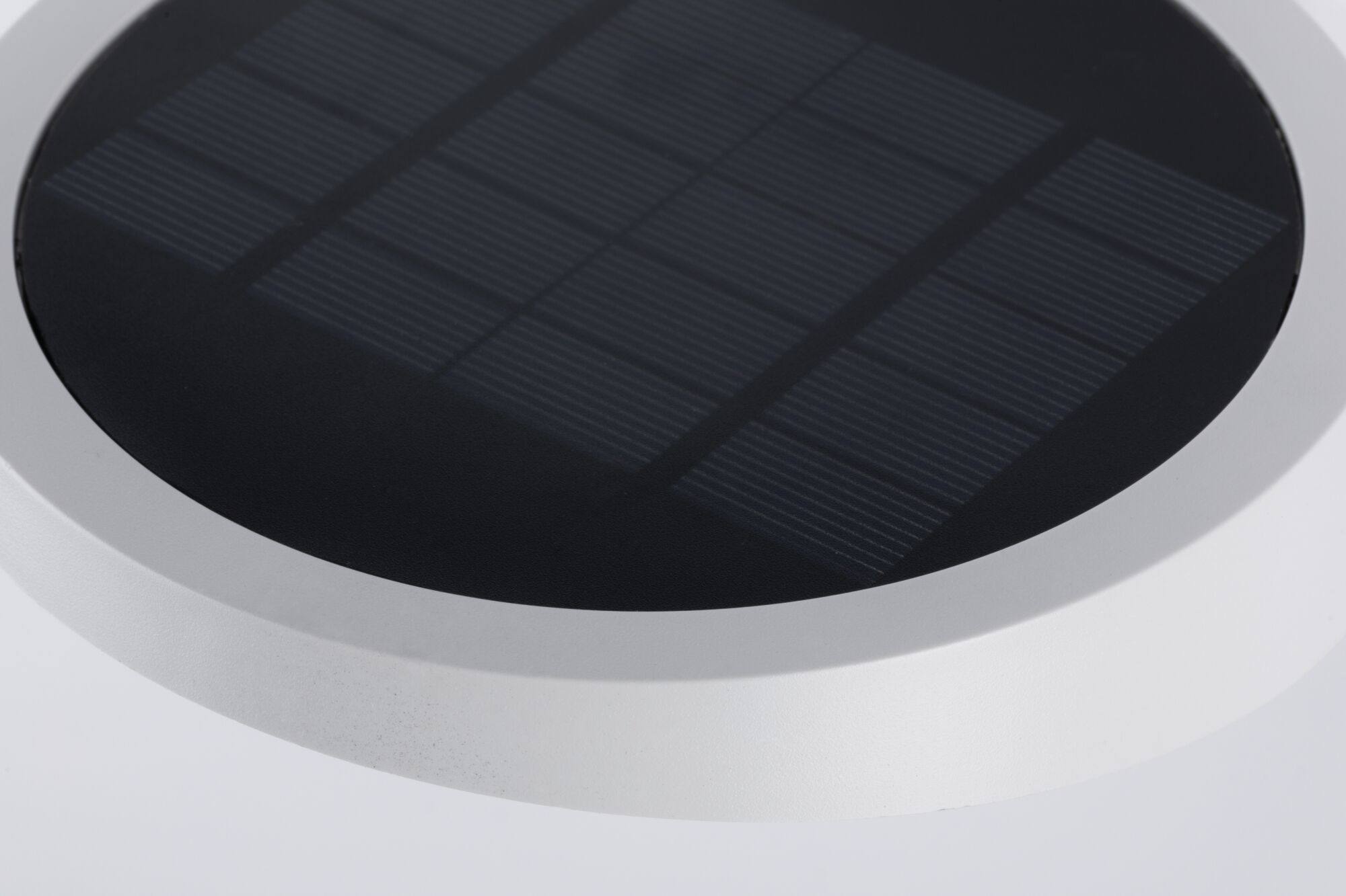 Rundes Solarpanel mit schwarzer Oberfläche und weißem Rahmen für energiesparende Beleuchtung