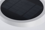 Rundes Solarpanel mit schwarzer Oberfläche und weißem Rahmen für energiesparende Beleuchtung