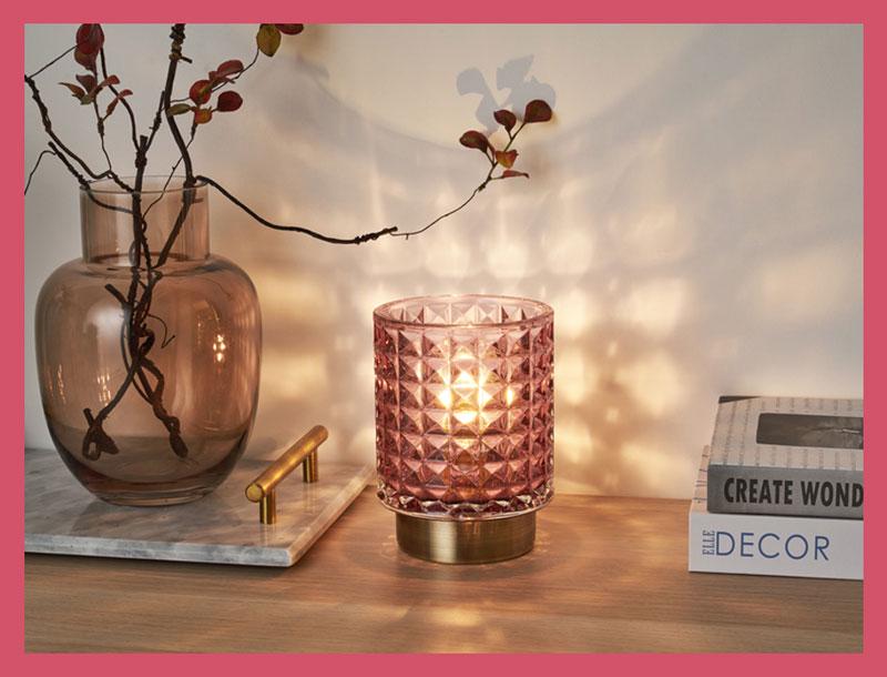 Pink glass table lamp with geometric pattern and brass base, decorative home lighting.