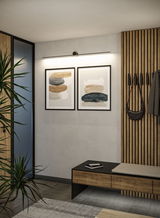 Slim black LED picture light above two abstract art prints in modern hallway with wood paneling.