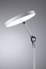 Lampadaire LED blanc moderne avec tête ronde et bras réglable en métal et plastique pour intérieur.