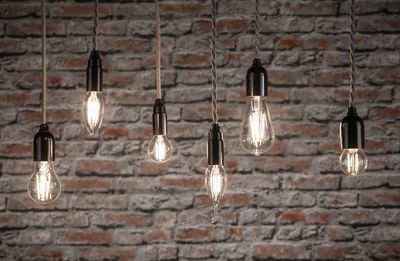 Zes heldere filament LED-lampen in verschillende vormen hangend voor een rode bakstenen muur voor decoratieve verlichting