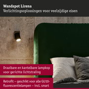 Zwarte metalen wandspot Lirena aan betonnen muur naast groen fluwelen hoofdeinde in slaapkamer