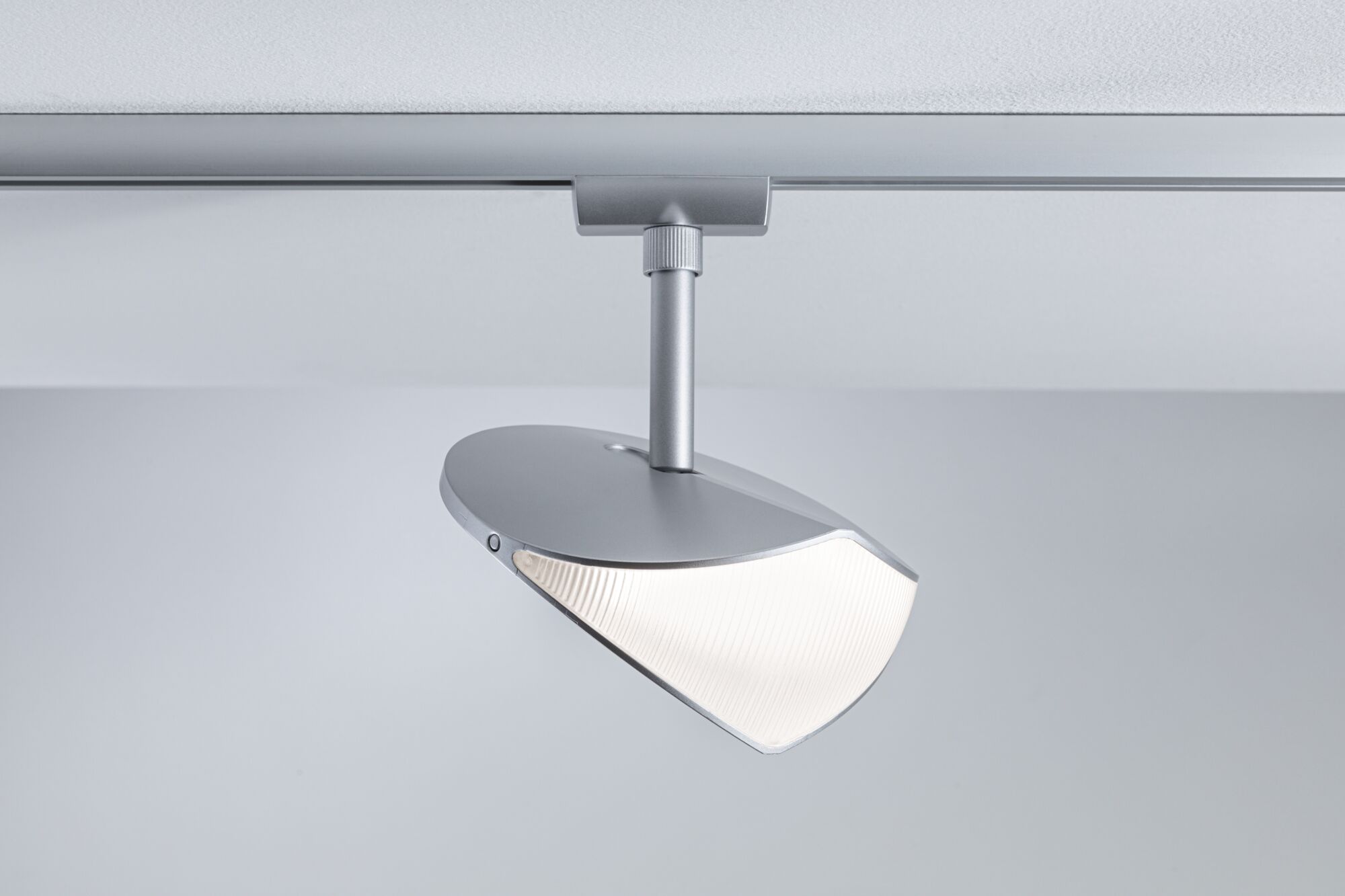 Moderner silberner LED-Strahler aus Metall an Schienensystem für flexible Raumbeleuchtung