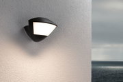 Schwarze Außenwandleuchte mit weißem Diffusor an strukturierter Wand, moderne LED-Außenbeleuchtung