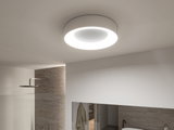 Round white ceiling light with LED ring in modern bathroom featuring natural stone wall and shower