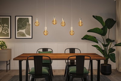 Moderner Essbereich mit Holz-Tisch, schwarzen Metallstühlen und warmen LED-Glühbirnen als Pendelleuchten.