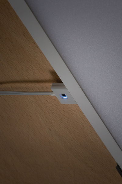 Witte LED-schakelaar met blauw licht op houten oppervlak voor moderne binnenverlichting bediening