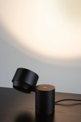 Black metal LED table lamp with round base and adjustable head for focused lighting