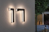 Moderne LED-husnummer 17 i sort materiale med varmt hvidt lys monteret på ydervæg.