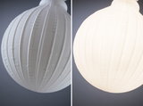 White glass pendant lamp with ribbed texture, modern design for ambient home lighting.