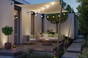 Beleuchtete Terrasse mit cremefarbenem Sonnensegel und warmweißen LED-Lichterketten für Außenbereiche
