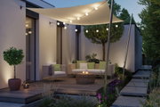 Beleuchtete Terrasse mit cremefarbenem Sonnensegel und warmweißen LED-Lichterketten für Außenbereiche