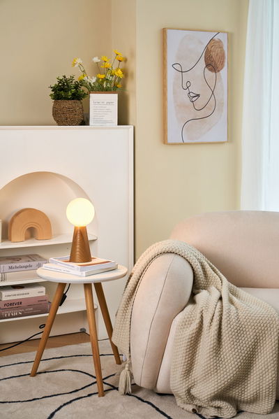 Moderner Holz-Tischleuchte mit rundem opalweißem Glas in gemütlichem Wohnzimmer mit beigem Sofa.