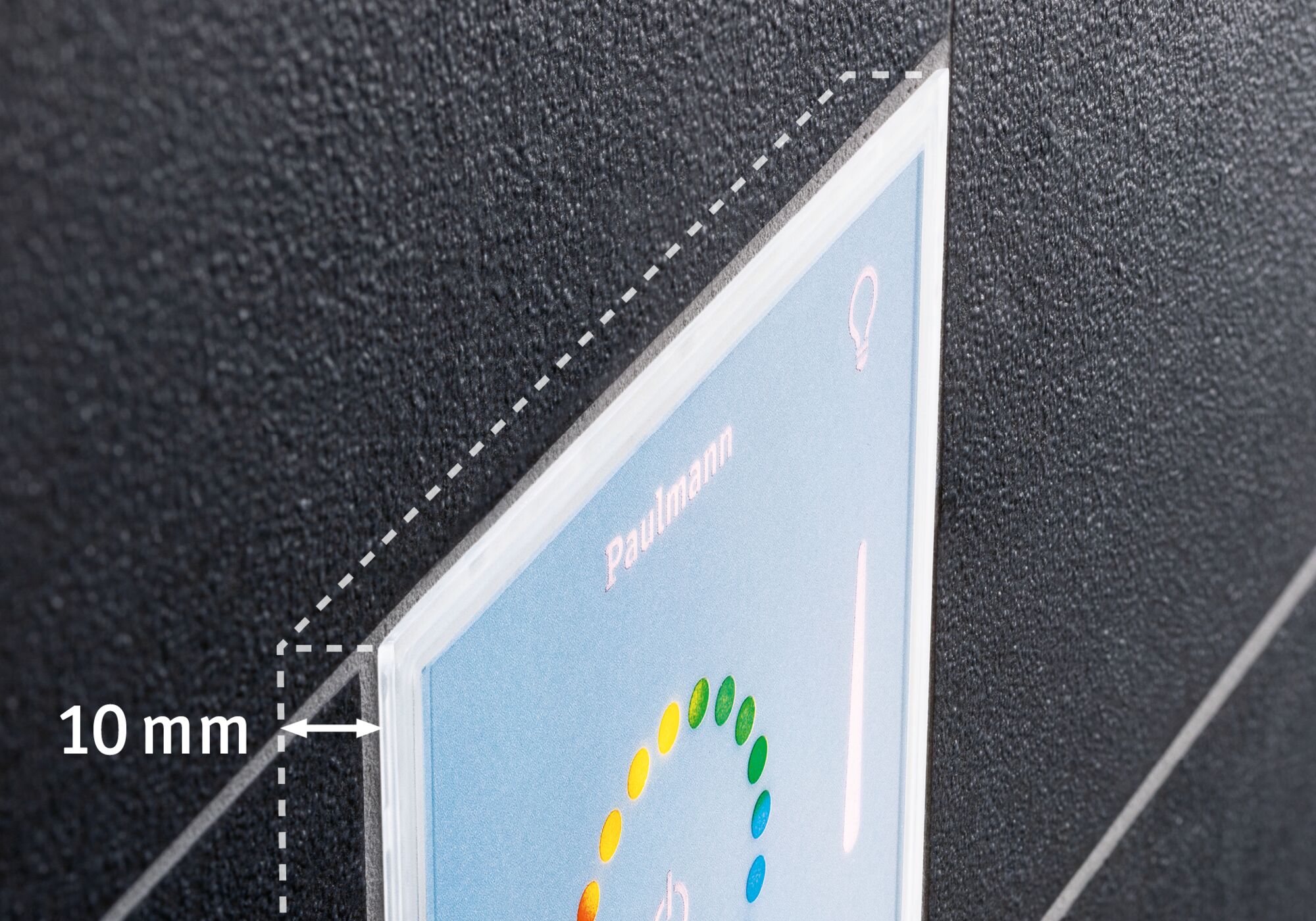 Close-up of 10 mm thick clear acrylic panel with colorful print on black textured background