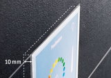 Close-up of 10 mm thick clear acrylic panel with colorful print on black textured background