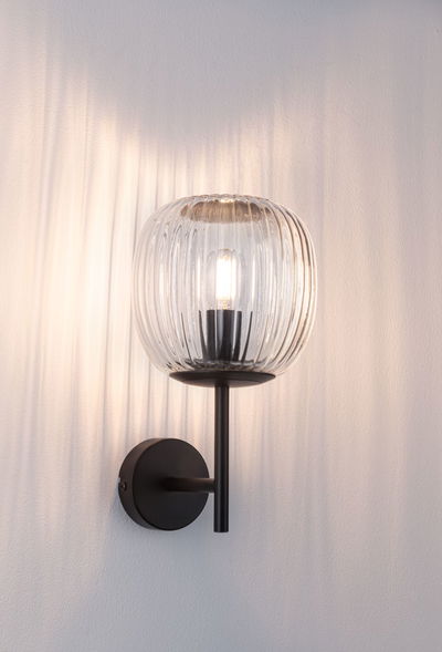 Wall lamp with ribbed clear glass and black metal frame for ambient lighting in modern interiors
