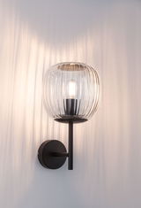 Wall lamp with ribbed clear glass and black metal frame for ambient lighting in modern interiors
