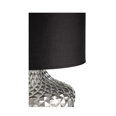 Table lamp with black fabric shade and silver textured metal base for modern interior lighting.
