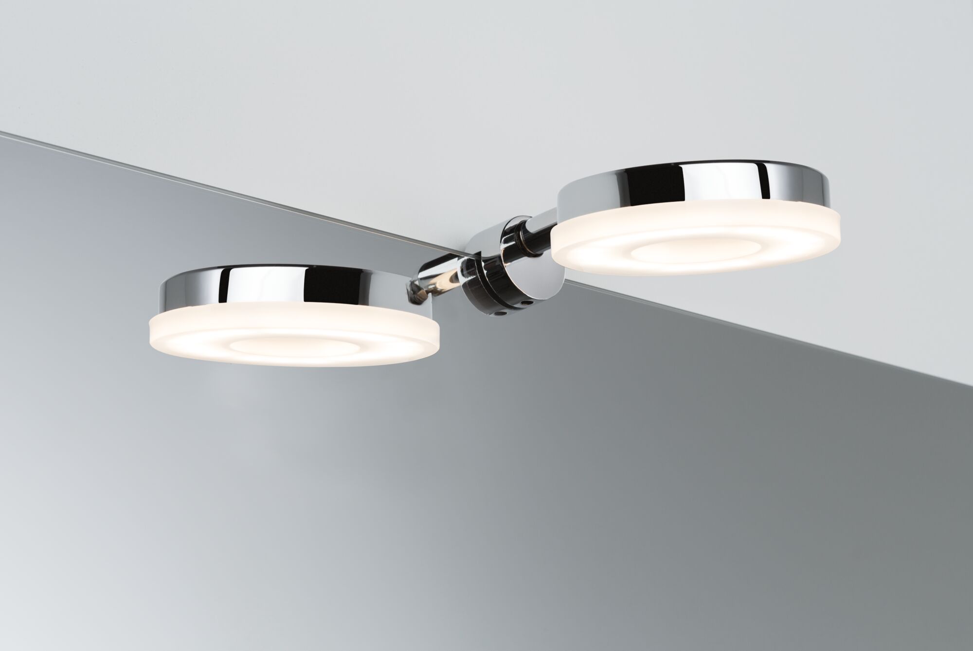 Moderne LED-væglampe i krom med to runde varm-hvide lyskilder til badeværelsesspejl.