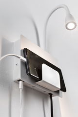 Witte wandhouder met geïntegreerde smartphone-oplaadplek en flexibele LED-leeslamp voor modern interieur