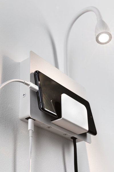 Witte wandhouder met geïntegreerde smartphone-oplaadplek en flexibele LED-leeslamp voor modern interieur