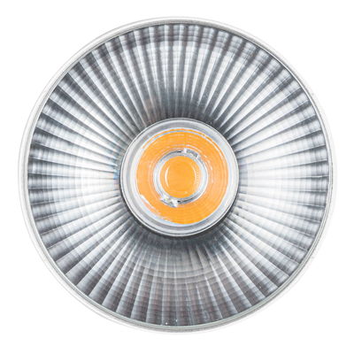 Round spotlight with silver aluminum reflector and orange LED light for accent lighting in interiors