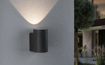 Modern black metal outdoor wall light with upward illumination for house facades and garden lighting.