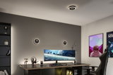 Modern gaming room with black desk, ultrawide monitor, and round LED ceiling and wall lights