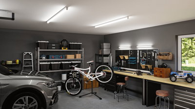 Moderne werkplaats met LED-plafondlampen, werkbank, fietsenstandaard en grijze auto in de garage.