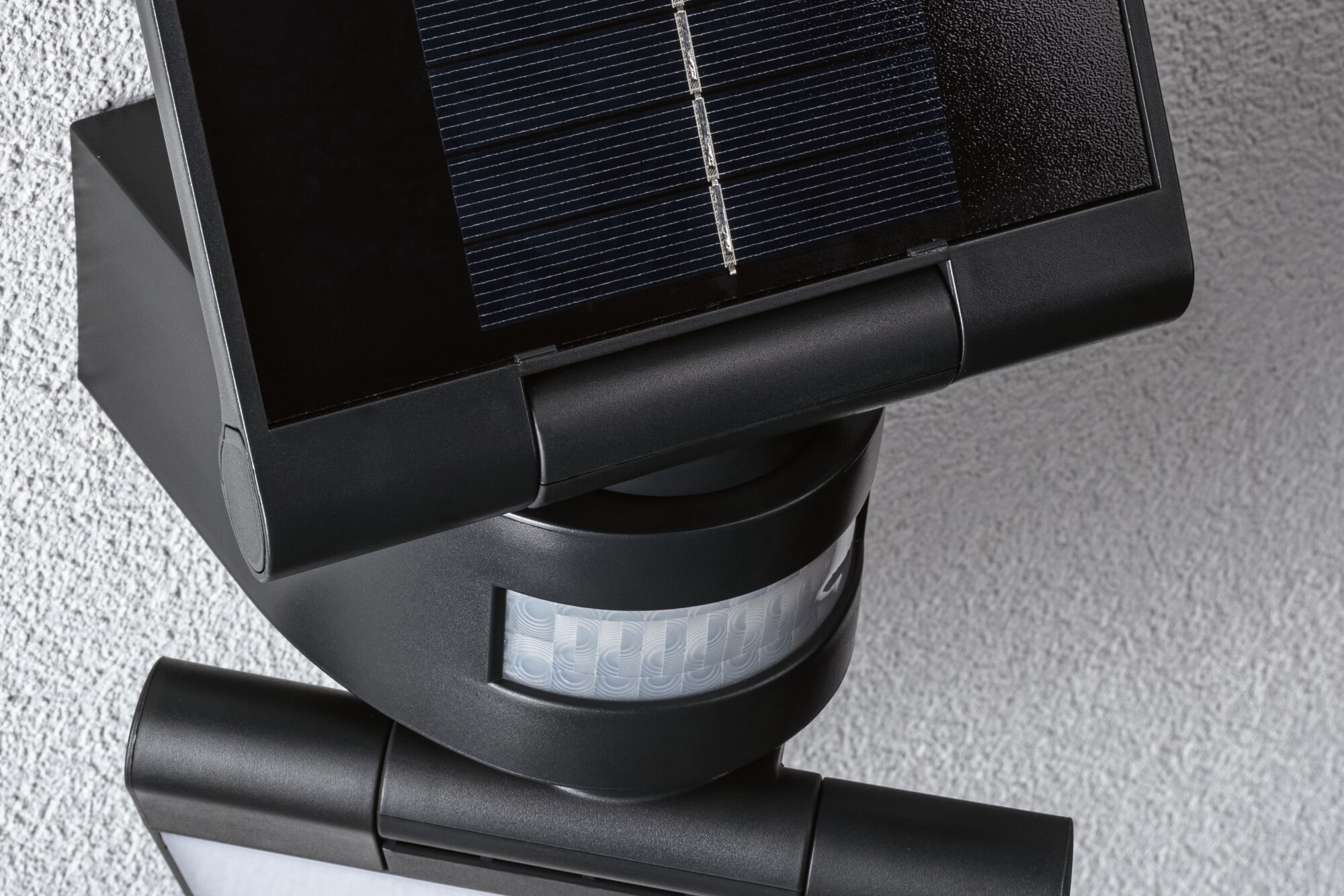 Schwarze Solarleuchte mit Bewegungsmelder und Kunststoffgehäuse an weißer Wand für Außenbeleuchtung