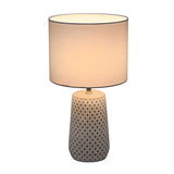 Bordlampe med beige mønstret keramisk fod og lys stofskærm til hyggelig belysning