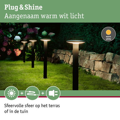 Moderne tuinverlichting met warm wit licht op groen gras naast stenen muur voor terras