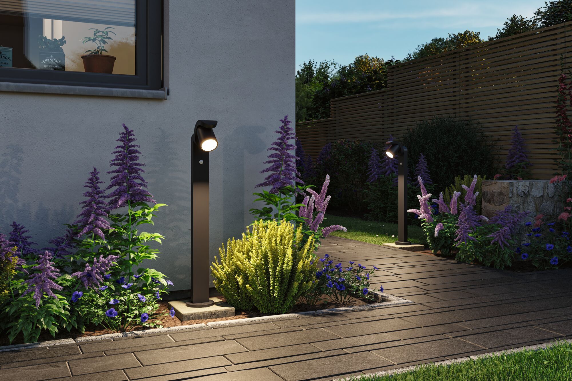 Moderne schwarze Außenleuchten aus Metall beleuchten Gartenweg mit lila und grünen Pflanzen bei Dämmerung